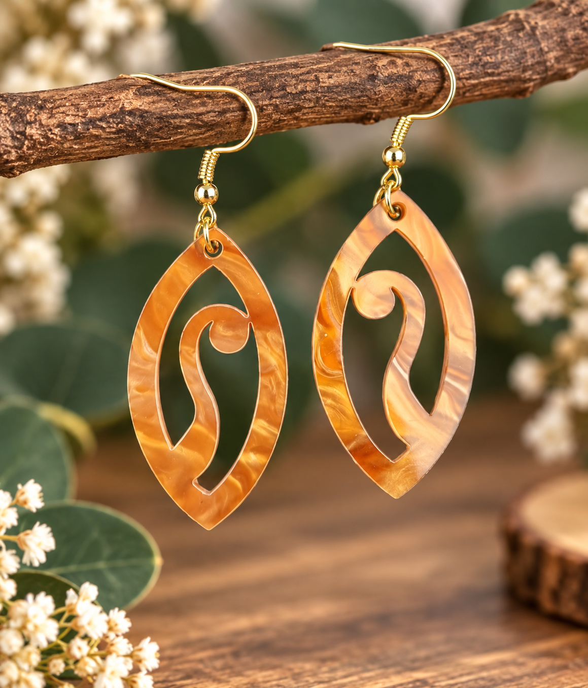 Amber pearlescent acrylic statement earrings with swirl cut-out design and gold-tone hooks, laser cut and made in New Zealand by Dopey Dog NZ