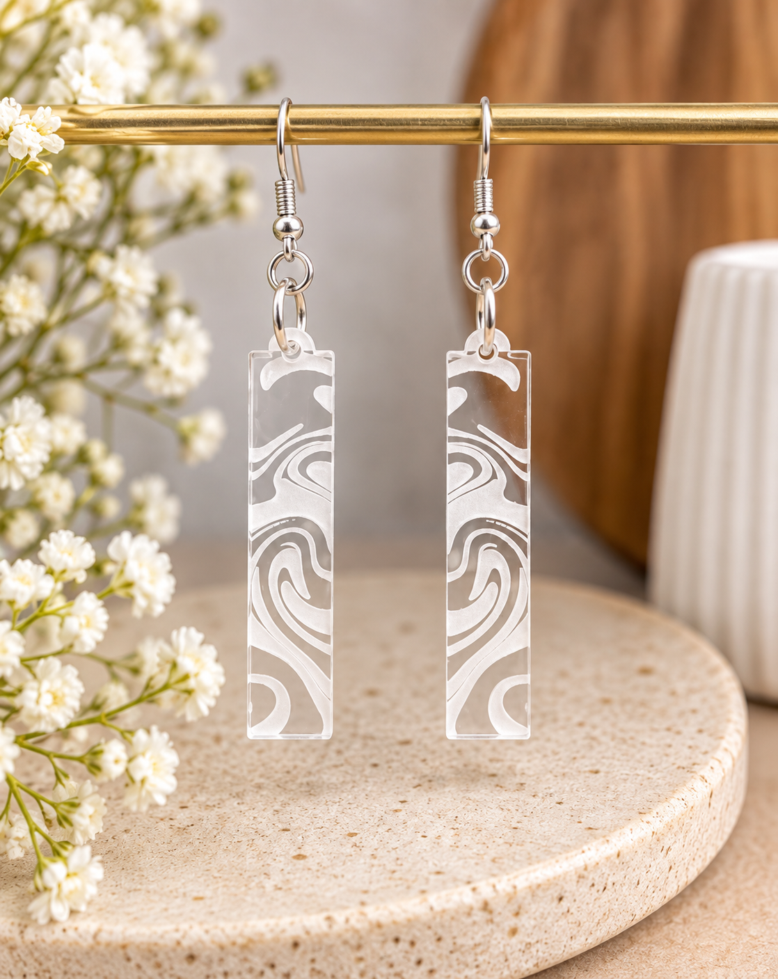 Clear acrylic earrings with white engraved swirl pattern, laser cut and made in New Zealand by Dopey Dog NZ.