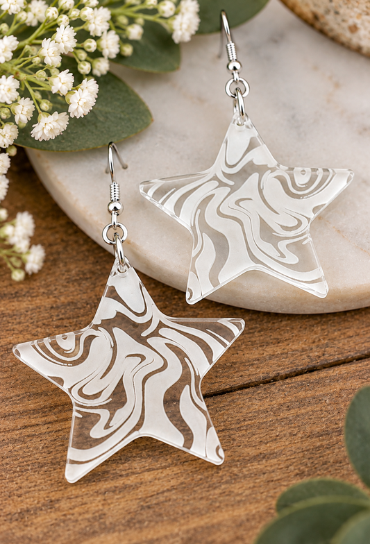 Clear acrylic star earrings with white laser engraved swirl pattern, handmade in New Zealand by Dopey Dog NZ
