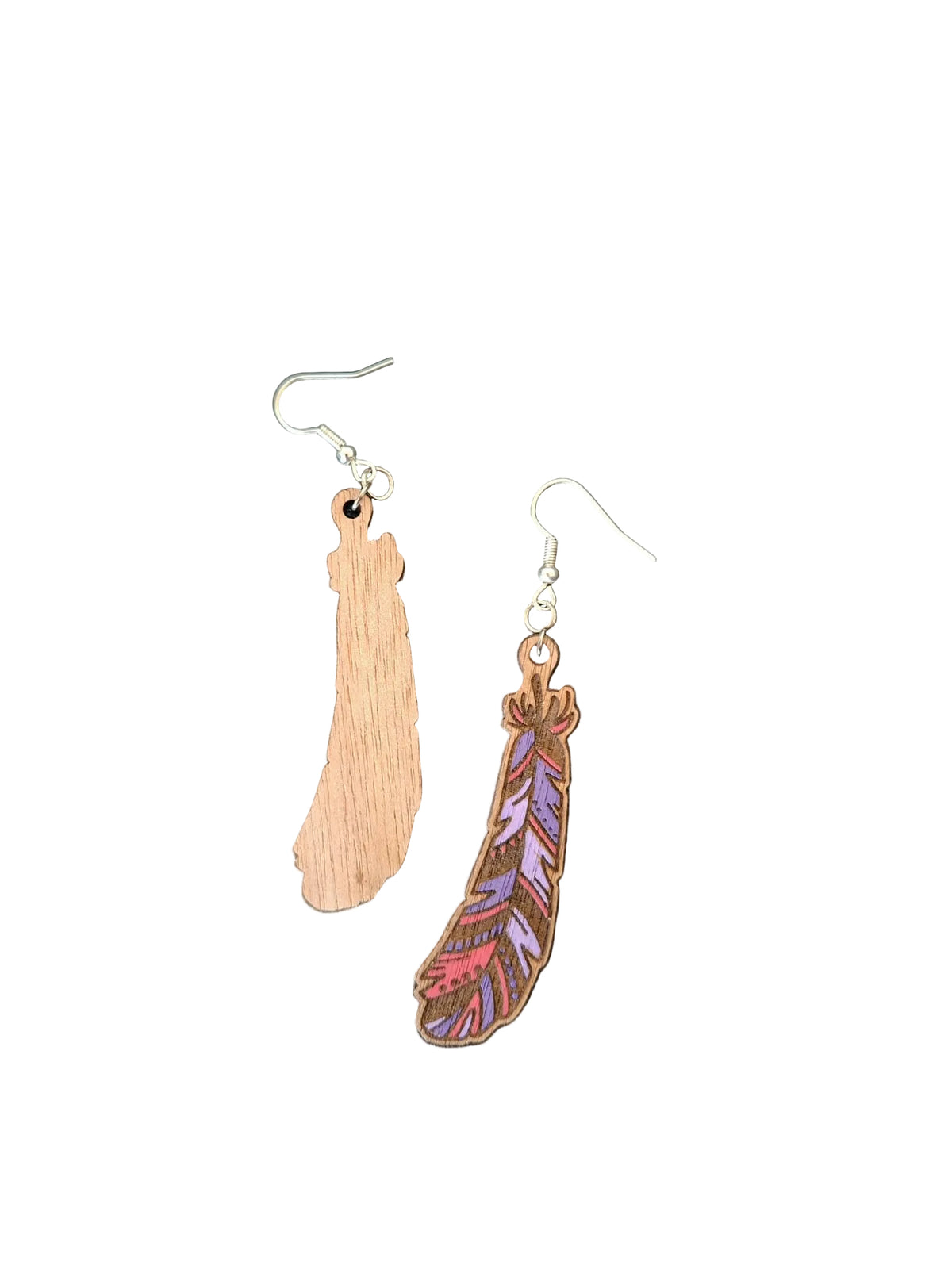 Two wooden feather-shaped dangle earrings on a dark textured background. One earring is a natural light wood color, and the other is a darker brown wood grain with colorful purple, pink, and orange painted feather details.